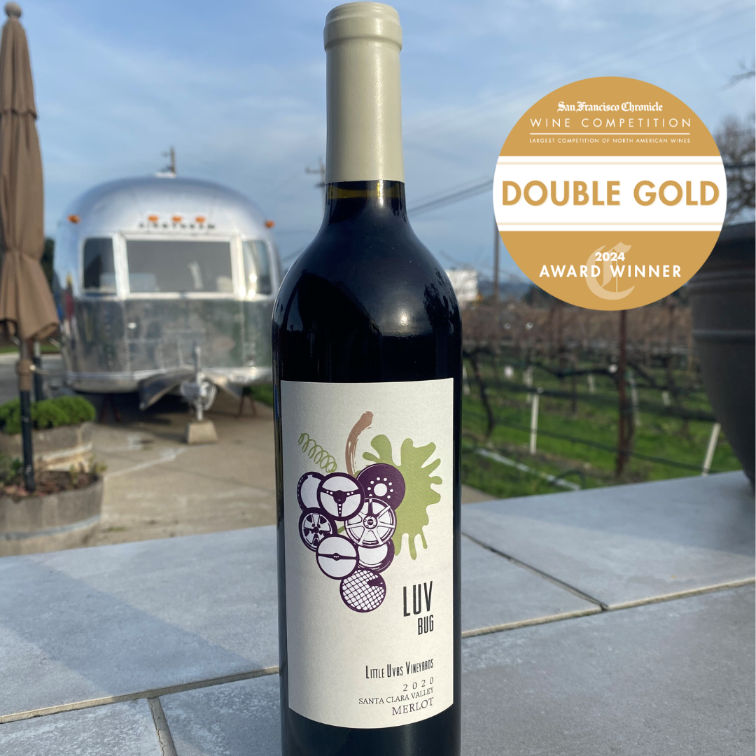 bottle of the 2020 LUV Bug Merlot with airsteam tasting room in the background